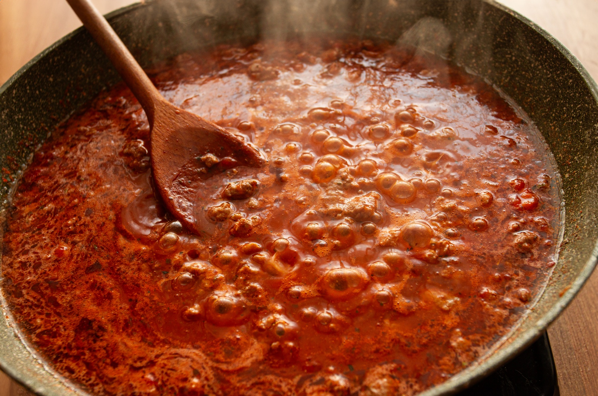 cooking, bolognese sauce, in a frying pan, stirring with a wooden spoon, tomato meat sauce, homemade