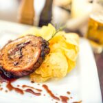 Porc chop on grill with chips as main course at local restaurant