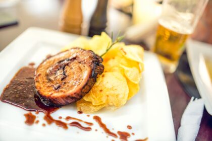 Porc chop on grill with chips as main course at local restaurant