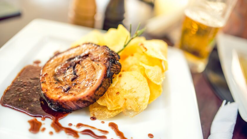 Porc chop on grill with chips as main course at local restaurant