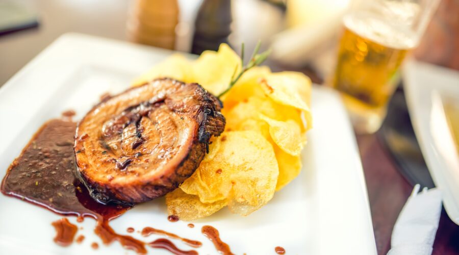 Porc chop on grill with chips as main course at local restaurant