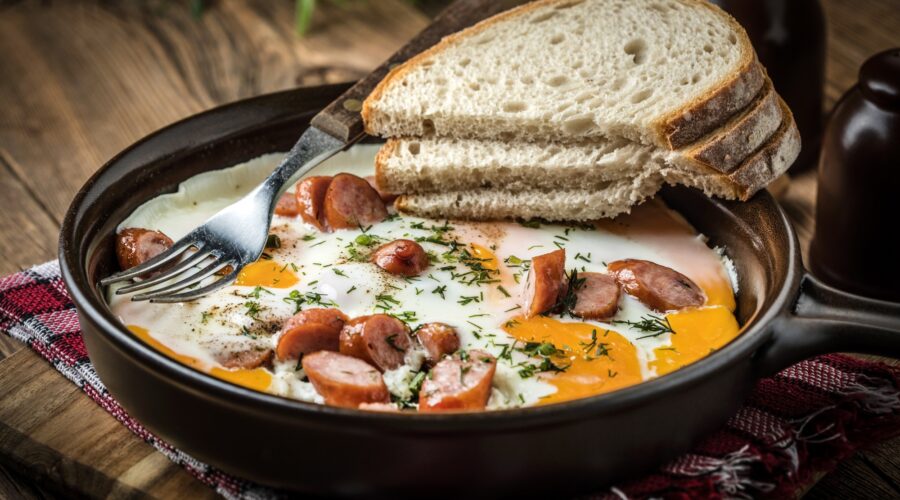 Tasty cooked egg with chopped sausages.
