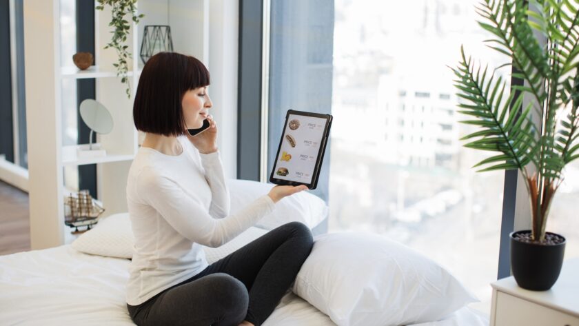 Woman with tablet and mobile ordering food with discount