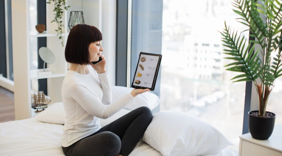 Woman with tablet and mobile ordering food with discount