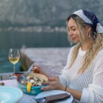 A woman eats mussels, a traditional Montenegrin dish, while sitting on the terrace of a restaurant