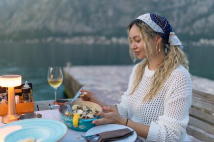 A woman eats mussels, a traditional Montenegrin dish, while sitting on the terrace of a restaurant