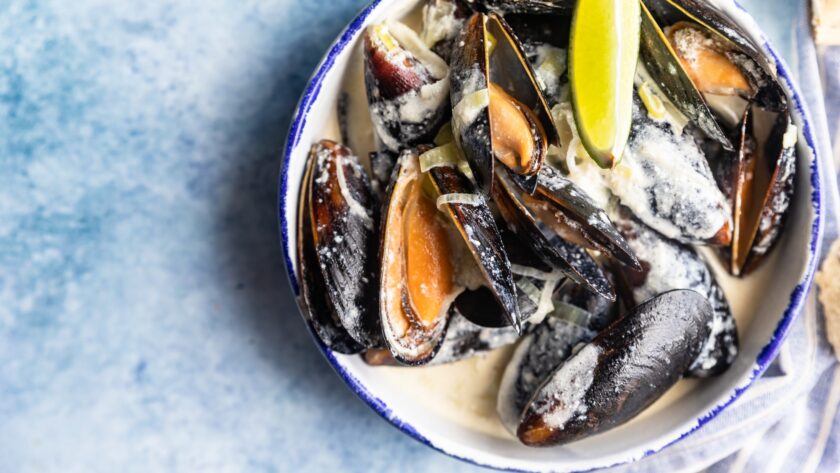 Blue mussels in wine sauce with lime and bread. Stew mussels in wine, leek and blue cheese. Seafood