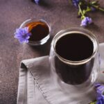 Chicory drink in a cup, powder and flower on the table