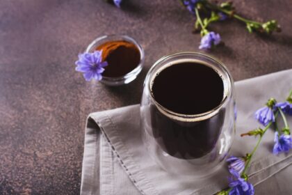 Chicory drink in a cup, powder and flower on the table