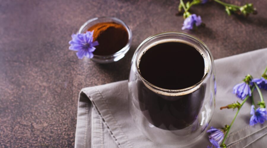 Chicory drink in a cup, powder and flower on the table