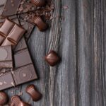 Chocolate bars and candies on a dark wooden background top view
