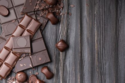 Chocolate bars and candies on a dark wooden background top view