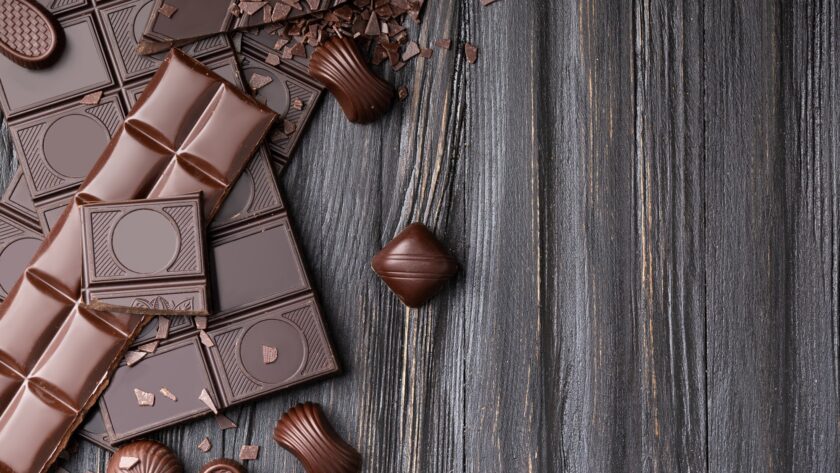 Chocolate bars and candies on a dark wooden background top view