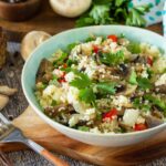 Diet food vegan concept. Vegan salad with couscous and champignons on a wooden table.