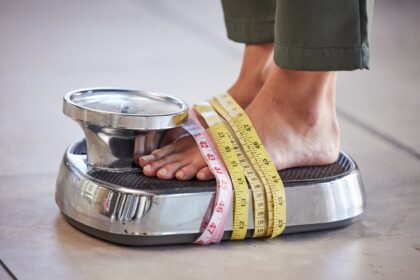 Diet, weight loss and feet of a woman on a scale for body check, measure and balance to lose weight