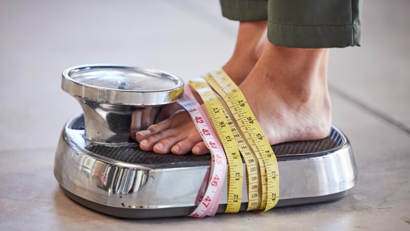 Diet, weight loss and feet of a woman on a scale for body check, measure and balance to lose weight
