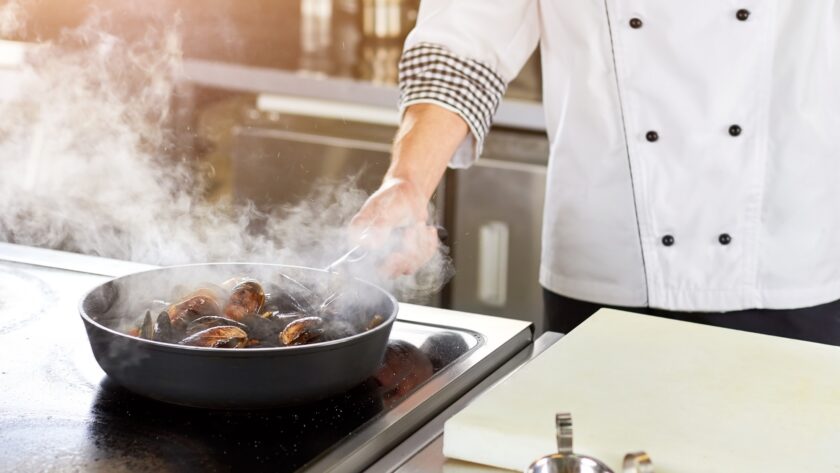 Shellfish mussels cooking in pan.