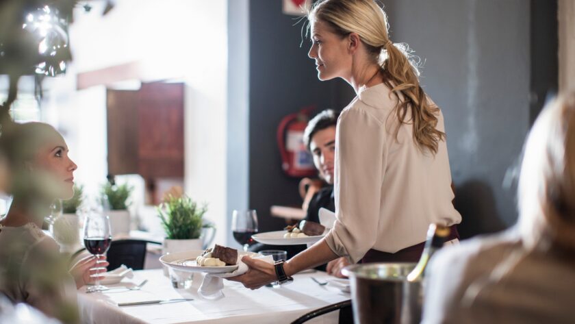 Waitress serving customers in restaurant