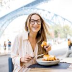 Woman with francesinha meal in Porto city