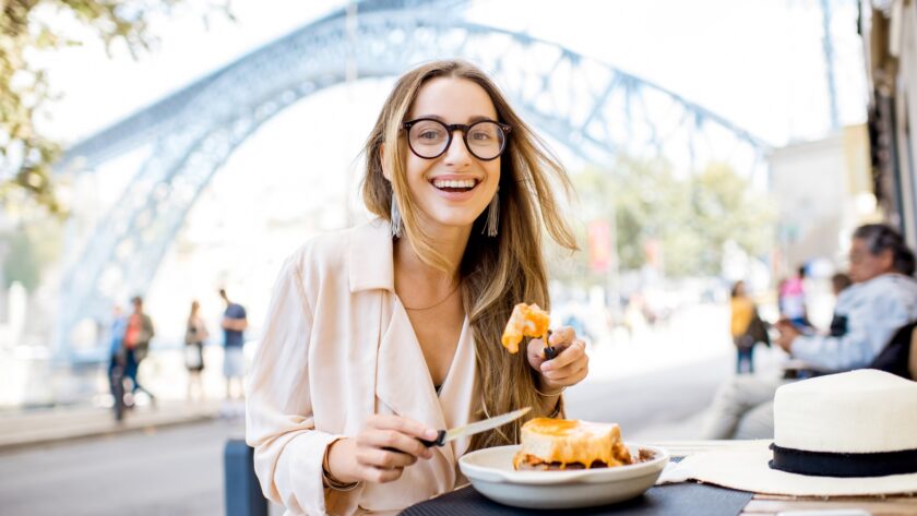 Woman with francesinha meal in Porto city
