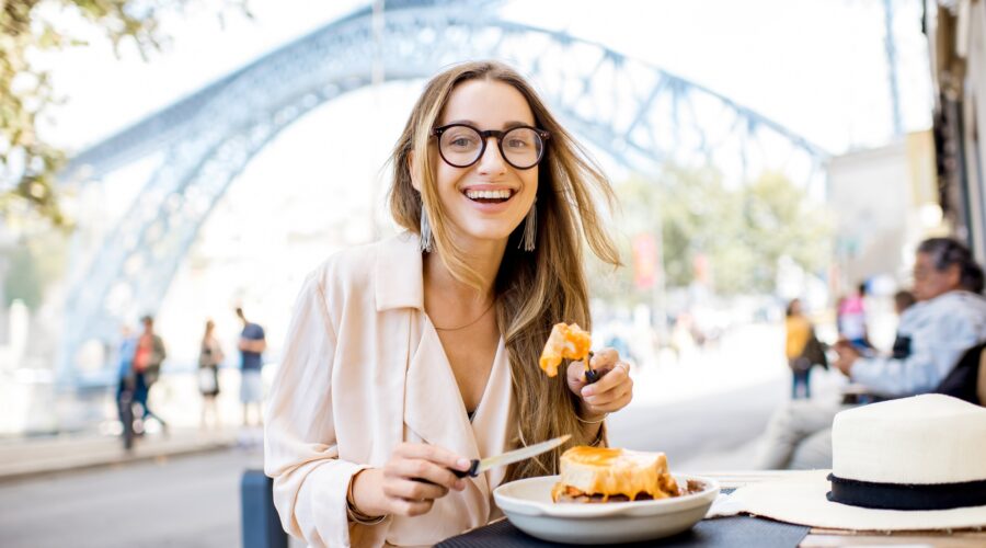 Woman with francesinha meal in Porto city